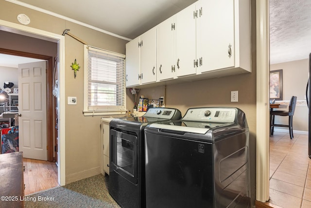 washroom featuring separate washer and dryer, baseboards, ornamental molding, and cabinet space