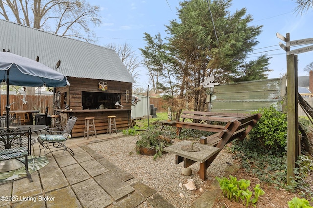 view of patio with outdoor dining area, outdoor dry bar, and fence