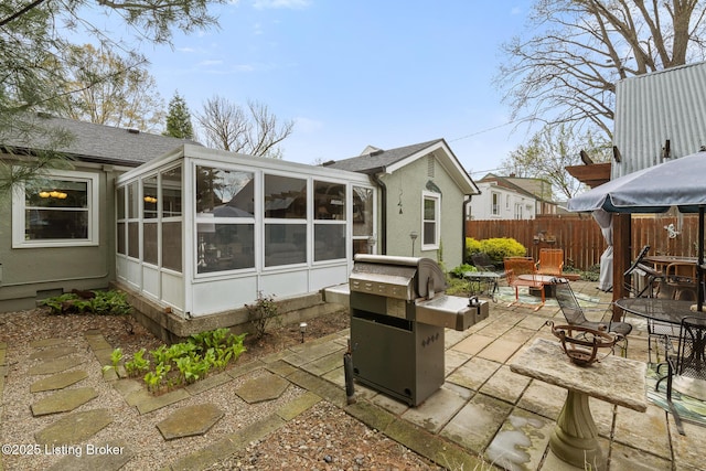 exterior space with grilling area, a sunroom, and fence
