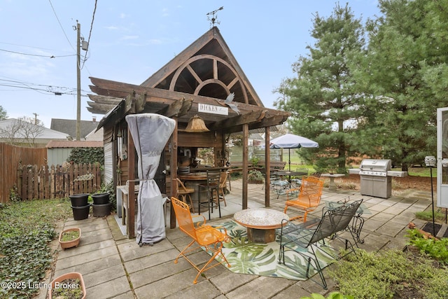 view of patio featuring outdoor dining area, grilling area, and fence