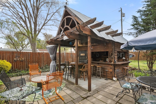 view of patio with a fenced backyard and outdoor dry bar