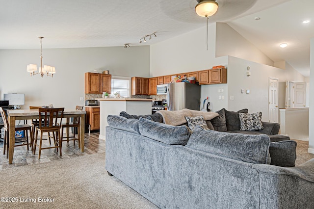 5416 Bannon Crossings Dr, Louisville, KY 40218 - living room featuring light carpet, high vaulted ceiling, and a chandelier
