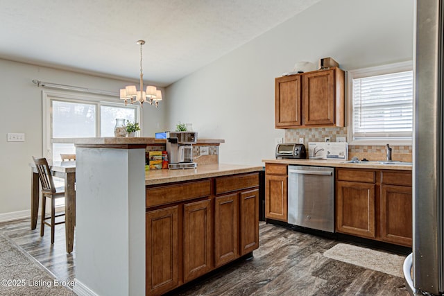 5416 Bannon Crossings Dr, Louisville, KY 40218 - kitchen featuring dark wood-type flooring, dishwasher, brown cabinets, and a notable chandelier