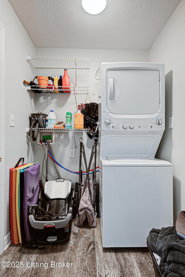 5416 Bannon Crossings Dr, Louisville, KY 40218 - laundry room featuring a textured ceiling, wood finished floors, stacked washing maching and dryer, and laundry area