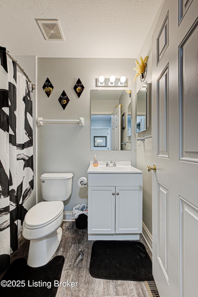 5416 Bannon Crossings Dr, Louisville, KY 40218 - full bathroom with wood finished floors, visible vents, toilet, vanity, and a textured ceiling