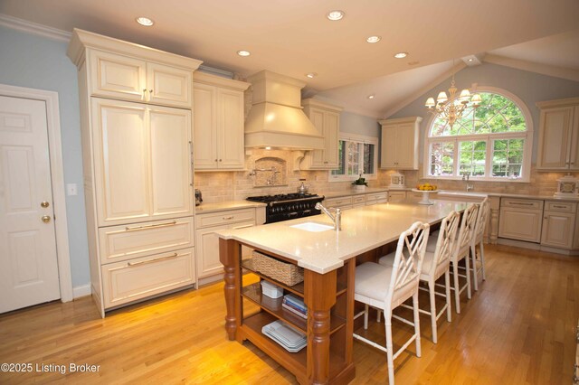 1304 Isleworth Dr, Louisville, KY 40245 - kitchen featuring custom range hood, a sink, an island with sink, a kitchen breakfast bar, and light wood-type flooring