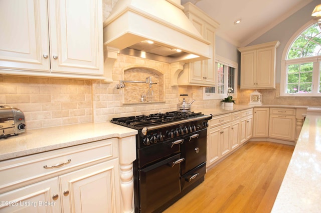 1304 Isleworth Dr, Louisville, KY 40245 - kitchen featuring premium range hood, double oven range, vaulted ceiling, light wood-style floors, and backsplash