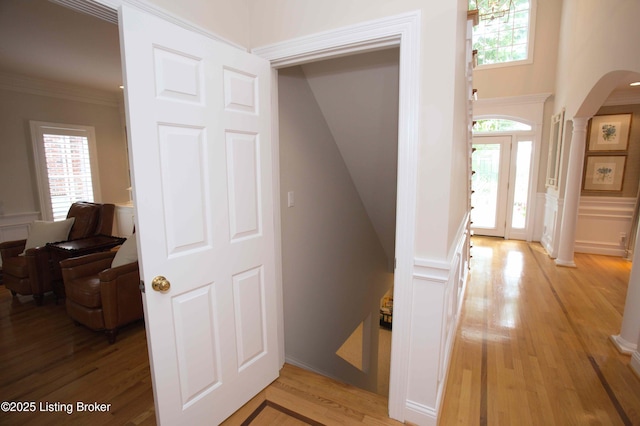 1304 Isleworth Dr, Louisville, KY 40245 - corridor featuring arched walkways, light wood-style flooring, a decorative wall, and ornate columns