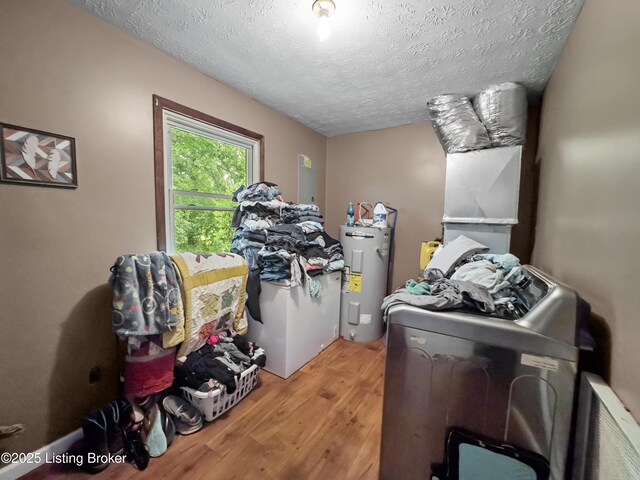 970 Elk Cave Branch Rd, Gravel Switch, KY 40328 - washroom with washer and dryer, water heater, wood finished floors, and a textured ceiling