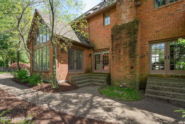 exterior space with entry steps, french doors, and brick siding