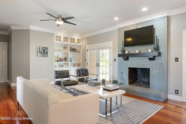 living area with ceiling fan, baseboards, wood finished floors, and a fireplace