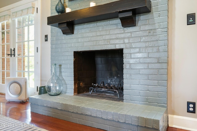 interior details with baseboards, wood finished floors, and a fireplace