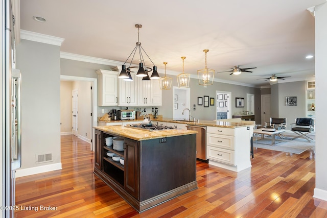kitchen featuring light wood-style floors, appliances with stainless steel finishes, white cabinetry, visible vents, and a peninsula