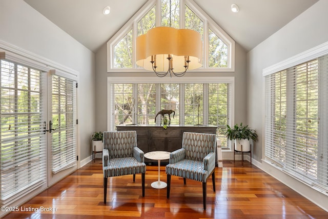 sunroom featuring wood-type flooring, high vaulted ceiling, baseboards, and plenty of natural light