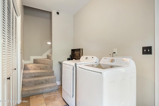 laundry area with stone finish floor, washer and clothes dryer, and laundry area