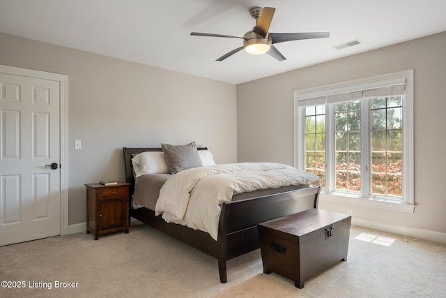 bedroom featuring baseboards, visible vents, light carpet, and ceiling fan