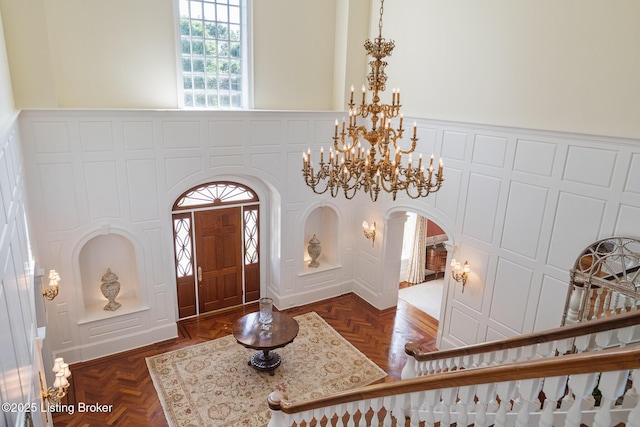 entrance foyer featuring arched walkways and a chandelier
