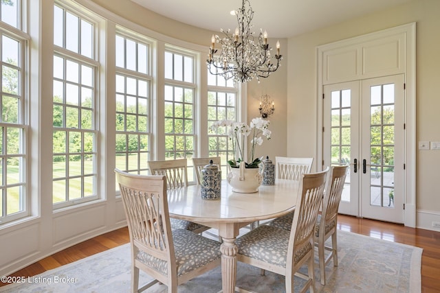 dining room featuring french doors, wood finished floors, and a chandelier
