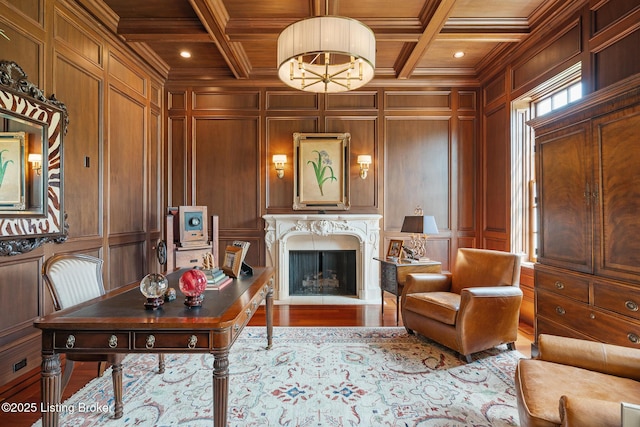 office space with a decorative wall, a wood ceiling with exposed beams, a high end fireplace, ornamental molding, and coffered ceiling