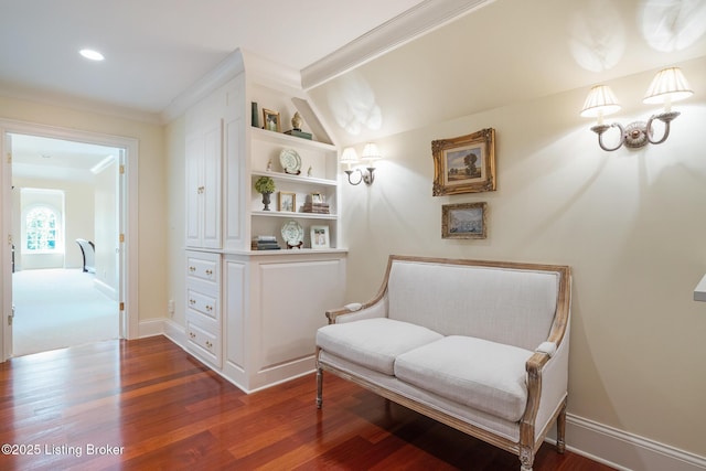 sitting room with wood finished floors and built in shelves