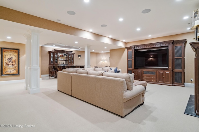 carpeted living room with decorative columns, recessed lighting, and bar area