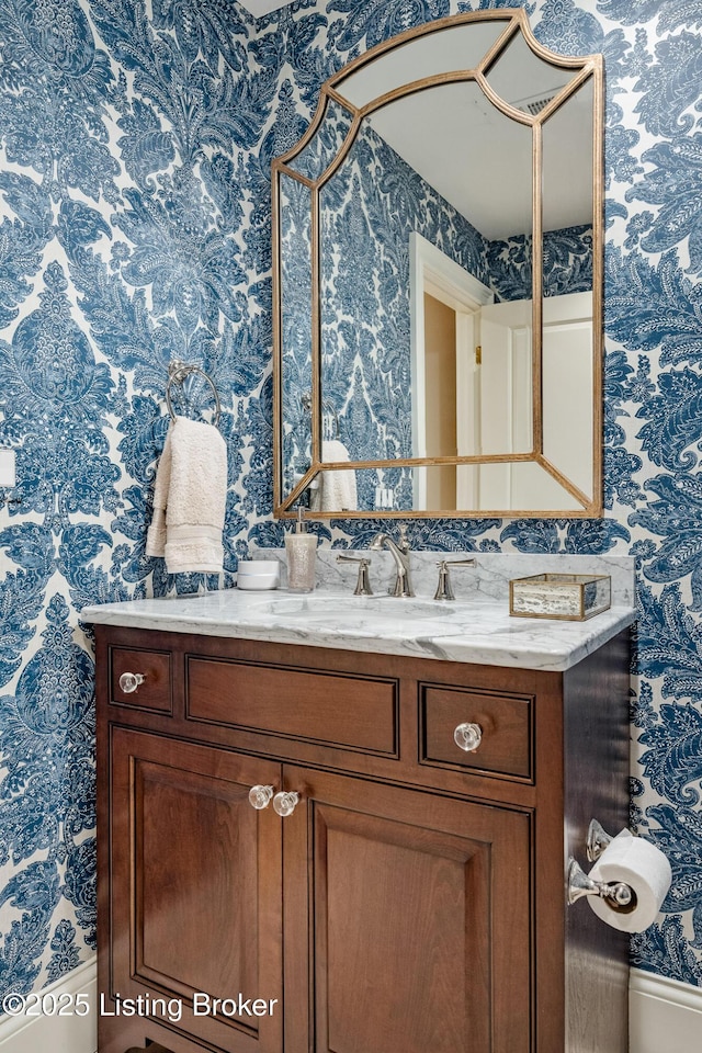 bathroom featuring wallpapered walls and vanity