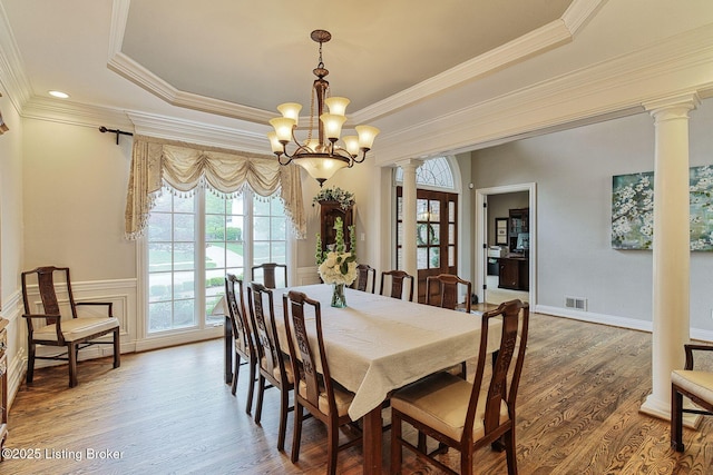 dining area with visible vents, decorative columns, crown molding, and a tray ceiling