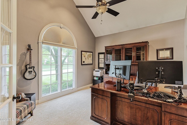 office space with light colored carpet, ceiling fan, baseboards, a wealth of natural light, and high vaulted ceiling