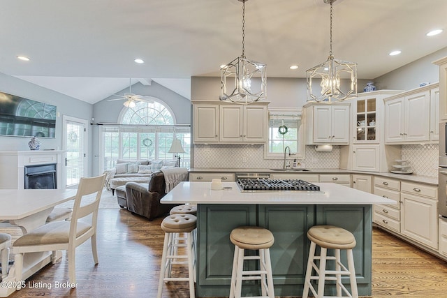 kitchen with open floor plan, a breakfast bar area, light wood-type flooring, and a sink