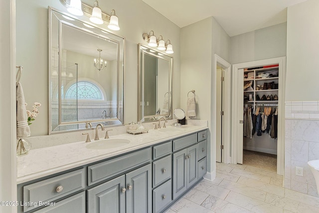 bathroom featuring double vanity, a sink, and a tub