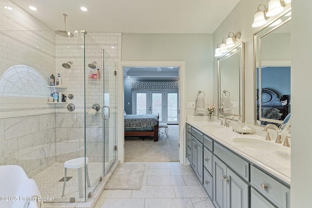 ensuite bathroom with a stall shower, double vanity, a sink, and ensuite bath