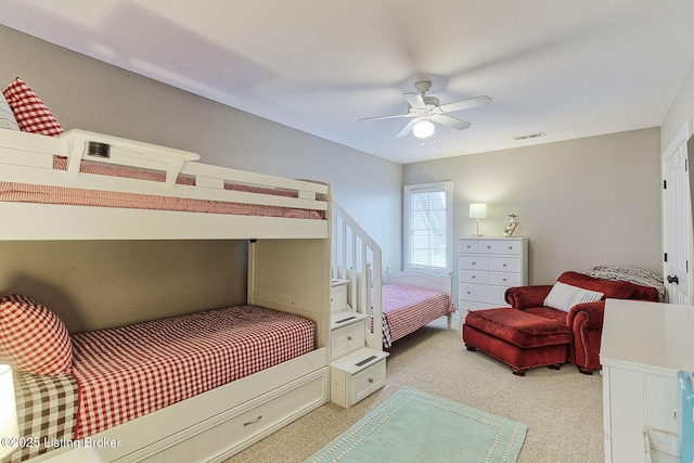 bedroom featuring visible vents, a ceiling fan, and light carpet