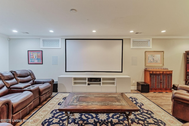 cinema with visible vents, recessed lighting, ornamental molding, and wood finished floors