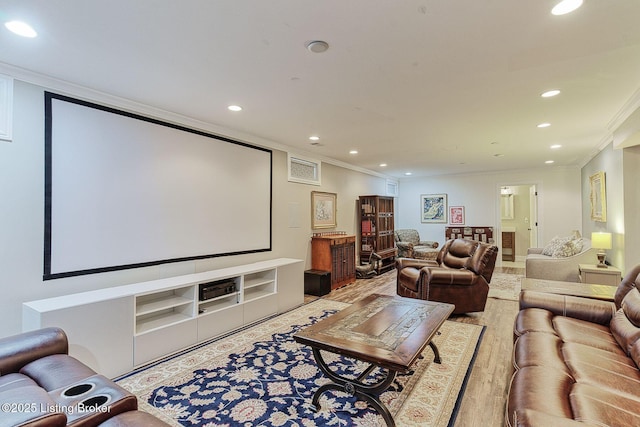 home theater with crown molding, light wood-style flooring, and recessed lighting
