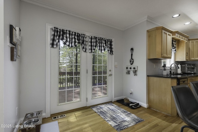 doorway to outside featuring baseboards, visible vents, recessed lighting, light wood-style floors, and crown molding