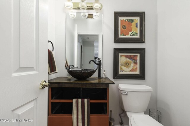 half bathroom with toilet and vanity