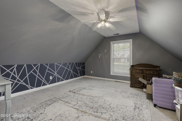 bonus room with vaulted ceiling, baseboards, visible vents, light colored carpet, and a ceiling fan