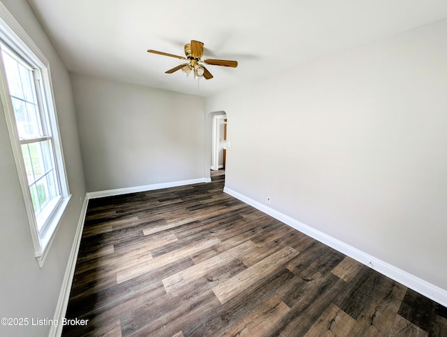 1104 Oleanda Ave, Louisville, KY 40215 - empty room featuring baseboards, dark wood-style flooring, a ceiling fan, and arched walkways