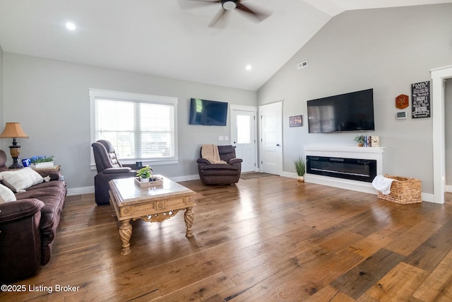 living room with hardwood / wood-style floors, baseboards, high vaulted ceiling, and ceiling fan