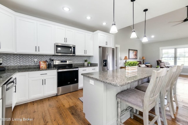 kitchen featuring appliances with stainless steel finishes, tasteful backsplash, white cabinetry, and light wood-style flooring