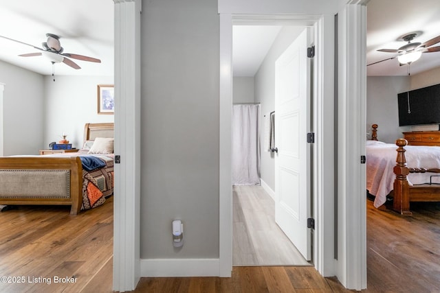 hallway featuring baseboards and wood finished floors
