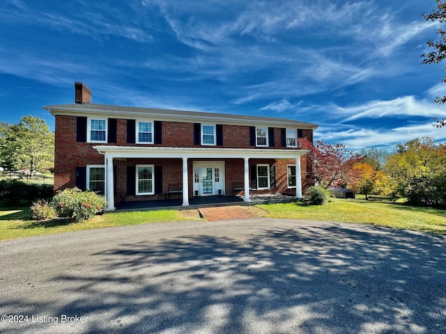 608 Lincoln Park Rd, Springfield, KY 40069 - colonial-style house featuring a chimney, a front lawn, brick siding, and a porch