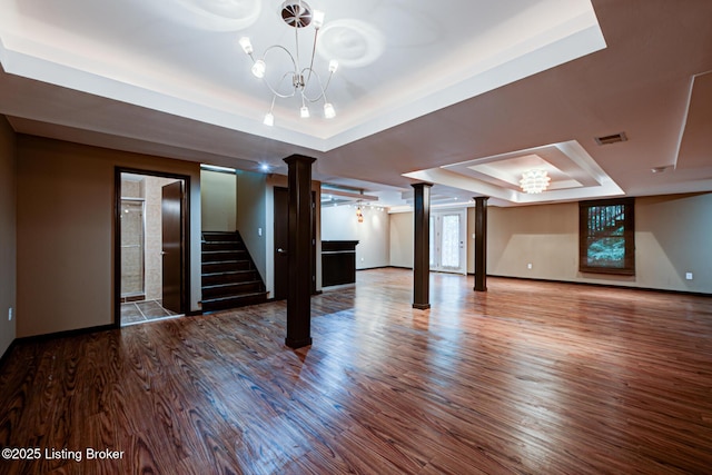 5204 Saratoga View Pl, Louisville, KY 40299 - unfurnished living room with a raised ceiling, ornate columns, a chandelier, wood finished floors, and baseboards
