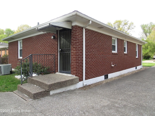 view of side of property with central air condition unit and brick siding