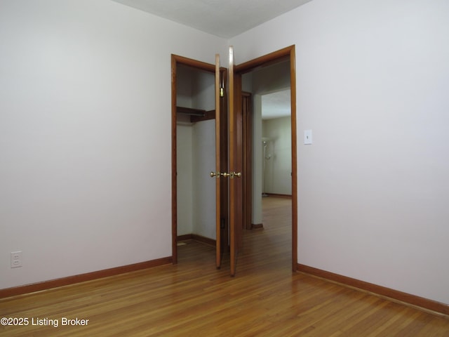 spare room with light wood-style flooring and baseboards