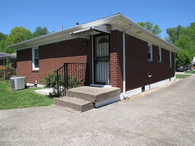 view of front facade with brick siding and central air condition unit