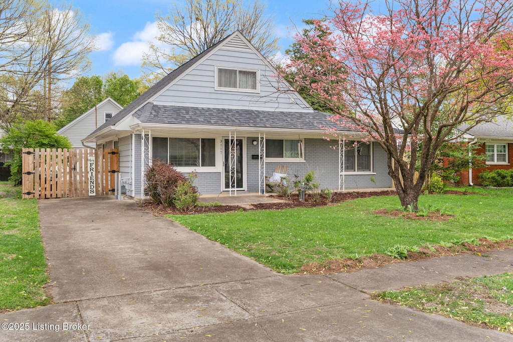 view of front of property with a gate, a front lawn, brick siding, a porch, and roof with shingles
