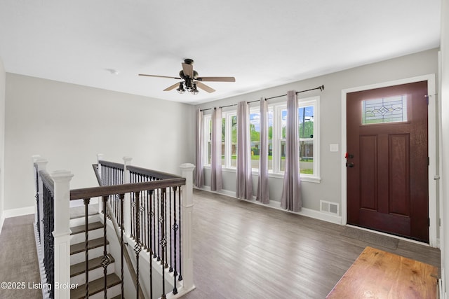 foyer featuring wood finished floors, visible vents, baseboards, and ceiling fan