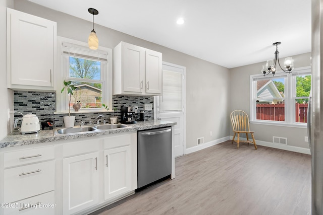 kitchen with white cabinets, dishwasher, visible vents, a wealth of natural light, and tasteful backsplash
