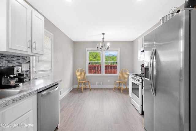 kitchen featuring white cabinets, light countertops, visible vents, light wood-style flooring, and appliances with stainless steel finishes
